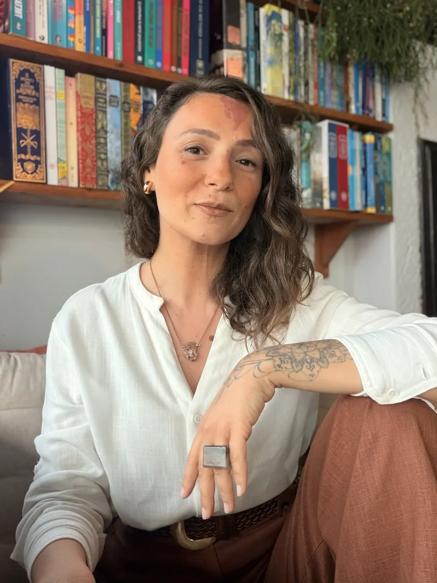 Mirela Marques diante da estante de livros